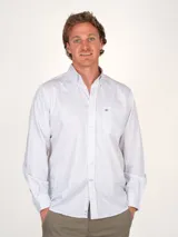 Camisa de hombre 100% algodón, de corte clásico, con estampado a cuadros pequeños en blanco y azul. Cuenta con cuello abotonado, bolsillo en el pecho y logo bordado en azul.