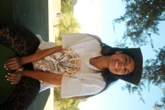 Remera blanca de manga corta con estampado frontal en tonos marrones y beige, de corte holgado.