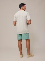 Short de baño azul marino con cintura elástica ajustable con cordón y logo de la marca bordado en rojo en la pierna izquierda.