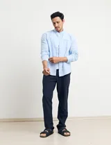 Camisa de cuello mao y manga larga, confeccionada en una mezcla de lino y algodón. Presenta un diseño de corte recto con botones en tono natural y un bolsillo pequeño en el pecho.