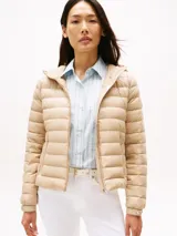 Campera acolchada ultraliviana de nailon reciclado, color beige, con capucha y cierre frontal. Presenta diseño acolchado horizontal y bolsillos laterales con cierre.