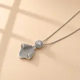 Collar de plata 925 con cadena fina y dije con forma de hoja o pétalo curvado, totalmente cubierto de pequeñas circonias brillantes, con una circonia central de mayor tamaño rodeada por un halo de piedras más pequeñas.