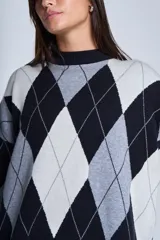 Sweater de punto con diseño de rombos en tonos beige y blanco, cuello redondo y corte holgado.