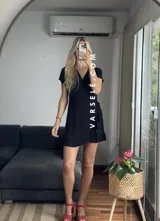 Vestido corto rojo con escote cruzado, mangas cortas y falda con volados. Se ajusta con lazo lateral tipo pareo.