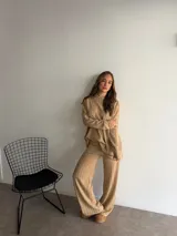 Buzo de punto color marrón chocolate, con cuello redondo y diseño holgado de manga larga con textura de trenzas verticales.