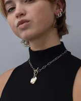 Earcuff de metal plateado, diseño orgánico y texturizado, que se ajusta al cartílago de la oreja sin necesidad de perforación.