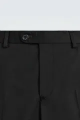 Pantalón de traje regular fit confeccionado en tejido de lana. Presenta bolsillos frontales, bolsillos traseros de vivo con botón y cierre frontal con cremallera y botón.