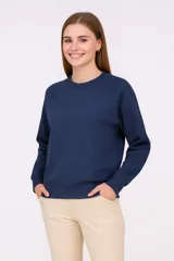 Buzo de cuello redondo y manga larga con diseño de corte raglán, confeccionado en tejido liso con puños y cintura acanalados.