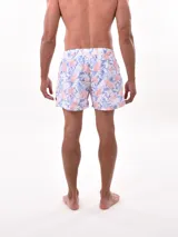 Short de baño blanco con estampado de hojas en tonos azules y rosados, cintura elástica con cordón ajustable.