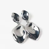 Caravanas colgantes de diseño orgánico con acabado metálico brillante, compuestas por dos piezas irregulares unidas por una argolla.