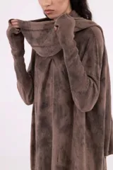 Vestido de tejido de punto gris oscuro con efecto tie-dye o marmolado, silueta amplia y largo midi. Posee cuello tortuga caído y mangas largas con abertura para el pulgar.