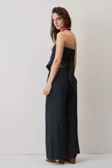 Blusa strapless azul marino de corte asimétrico con terminación en punta y flecos sutiles en el borde inferior, diseño de escote palabra de honor.