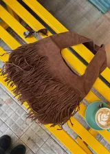 Bolso bandolera grande de ecocuero color marrón con flecos largos.