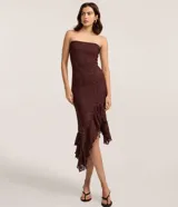Vestido midi strapless de encaje floral bordó, con corte ajustado hasta la cadera y bajo asimétrico decorado con volados.