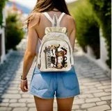 Mochila Lucy de cuero blanco y detalles dorados, con diseño de arte pintado a mano en el bolsillo frontal, cierre superior y correas ajustables.