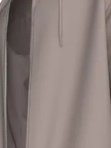 Buzo con capucha color lila, con cierre frontal completo, cordones ajustables en la capucha, bolsillos laterales y puños y dobladillo acanalados.