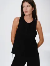 Chaleco de cuero negro con corte oversize, cuello redondo y diseño sin mangas. Presenta detalles de costuras texturizadas en la zona de los hombros.