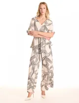 Conjunto de dos piezas compuesto por una camisa de cuello solapa con escote en V y mangas cortas con trabilla, y un pantalón estilo palazzo de tiro alto con cintura elástica y bolsillos laterales. Ambas prendas presentan un estampado geométrico lineal en tonos neutros y se complementan con un cordón trenzado para ajustar la cintura.