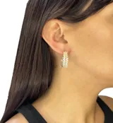 Aros tipo argolla dorados con forma de espiga, hechos en acero con incrustaciones de zirconia.