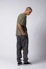 Remera oversize color marrón con hombros caídos y un bordado minimalista de un joystick en blanco en el frente. Incluye una etiqueta aplicada en la parte superior de la espalda.