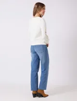 Buzo blanco de modal, corte clásico, con mangas largas abullonadas y apliques de crochet floral en los hombros y parte superior de las mangas.