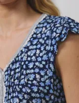 Conjunto de pijama de short y remera en tejido soft estampado. Remera de escote en V con aplique de puntilla, botones y detalle plisado. Short con cintura elastizada.