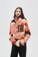 Buzo de polar tipo canguro con cuello alto y cierre frontal parcial. Presenta un diseño estampado con bloques de colores en tonos rosado, naranja, marrón y crema, y cuenta con un bolsillo frontal con cierre en contraste de color marrón.
