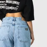Pantalón de jean estilo ultra baggy con diseño de paneles curvos en las piernas. Presenta un lavado claro, bolsillos traseros amplios y costuras reforzadas que definen su silueta holgada y voluminosa.