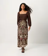 Vestido midi de viscosa con estampado de follaje, escote cuadrado y mangas largas con puños elásticos. Presenta un corte evasé y un lazo fino en la cintura.