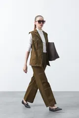 Chaleco de estilo utilitario color bordó con pespuntes blancos a contratono. Presenta solapas, cierre frontal con botones, bolsillos delanteros y un diseño estructurado.