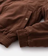Campera bomber de pana color marrón, con cuello polo, cierre frontal con cremallera y puños y bajo elásticos.