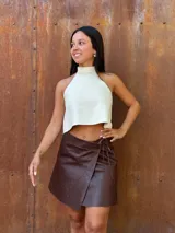Minifalda tipo pareo confeccionada en cuero color chocolate, con diseño cruzado y cierre mediante tiritas laterales ajustables.