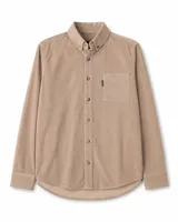 Camisa de manga larga confeccionada en pana gruesa color beige, con cuello abotonado, cierre frontal con botones y un bolsillo en el pecho con etiqueta decorativa.