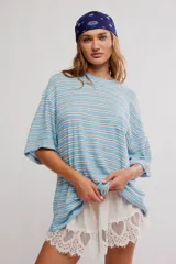 Remera oversize de manga corta a rayas celestes y blancas, con cuello redondo y un bolsillo aplicado en el pecho.