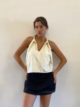 Minifalda negra con short incorporado, de diseño deportivo con cintura ajustable que permite usarla de tiro alto o bajo y bolsillos laterales.