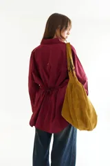 Camisa oversize de corte holgado con estampado de rayas verticales. Presenta cuello camisero, cierre frontal con botones a contraste y cordones integrados en la cintura para ajustar la silueta. Posee mangas largas con puños rectos.