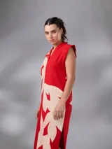 Vestido largo y recto sin mangas, confeccionado en paño de algodón con escote en V y cuello mao. Cuenta con un diseño bicolor en rojo y crudo con estampado exclusivo de hojas.