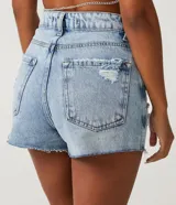 Short de jean de tiro alto, color celeste, con bolsillos y detalles de strass y estrellas.