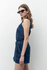 Blusa sin mangas de jean azul oscuro con escote redondo y bolsillo de parche en el pecho.