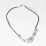 Collar con cordón negro y cadena plateada ajustable. Presenta dijes de diferentes tamaños con forma de piedras irregulares color plateado.