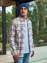 Sobrecamisa a cuadros color crema, marrón y blanco, de manga larga con cierre de botones y bolsillos en el pecho.