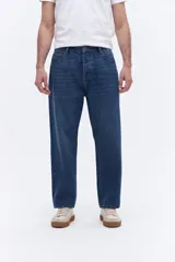 Jean de corte baggy con tiro medio, diseño amplio y relajado en piernas y cadera, con cierre frontal y bolsillos laterales.