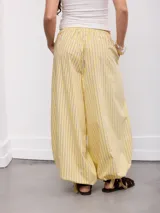 Pantalón palazzo tiro alto con estampado a rayas horizontales rojas, celestes y blancas. Cuenta con cintura elástica y puños ajustables en los tobillos.