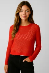 Sweater de viscosa color rojo, con diseño calado, corte holgado y cuello bote.