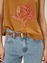 Musculosa de algodón color azul marino, con escote en V y un bordado artesanal de flor en el frente con contorno naranja y relleno dorado.