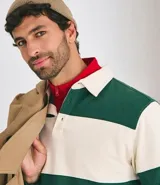 Chomba de manga larga con cuello polo y cierre frontal con botones. Presenta un diseño de rayas horizontales anchas en bloques de color verde y beige. Confeccionada en tejido de algodón de alta calidad.