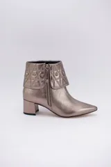 Botas cortas de cuero negro con taco cuadrado y punta fina. Presentan cuello caído capitoneado con apliques brillantes y cierre lateral con cremallera.