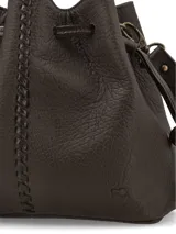 Cartera bandolera de cuero graneado color marrón chocolate, de formato tipo saco con cierre fruncido mediante cordones ajustables. Presenta costuras decorativas centrales y correa larga regulable.
