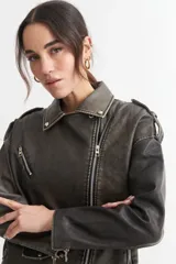 Campera tipo biker de cuero sintético color gris oscuro con efecto desgastado, cierre cruzado con cremallera, cuello con solapas y múltiples bolsillos con cremallera.