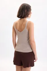 Musculosa de punto con hilo lurex en color beige, de corte ajustado al cuerpo, con escote en V y tirantes finos.